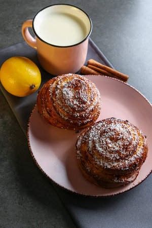 Cinnamon and coconut lemon buns on a pink plate on a gray tableの写真素材