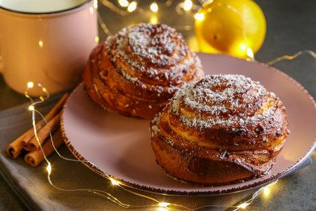 Cinnamon and coconut lemon buns on a pink plate on a gray tableの写真素材