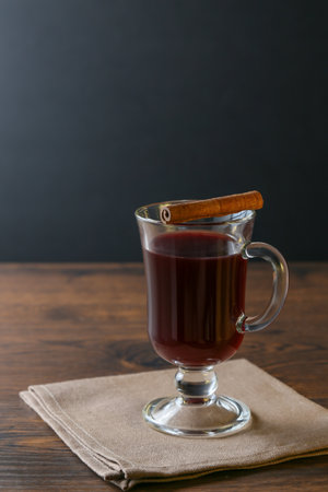 Mulled wine in glass cups with cinnamon and oranges on a wooden table.の写真素材