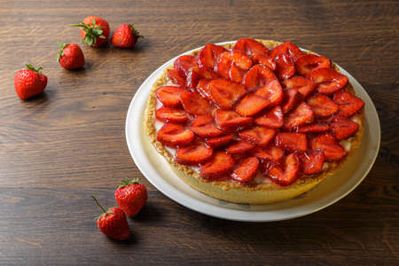 Homemade strawberry pie with syrup on a ceramic platter.の写真素材