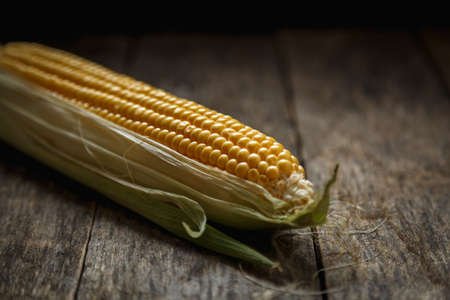 Fresh corn on the cob on a rustic wooden table, close up. Delicious and healthy food.の写真素材