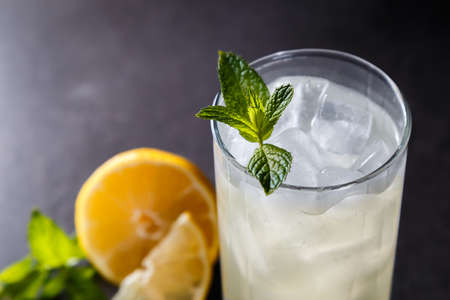 Refreshing summer non-alcoholic lemonade with ice, fresh mint and lemon. Top view, place for text. Fruit background with copy space. Still life food.の写真素材