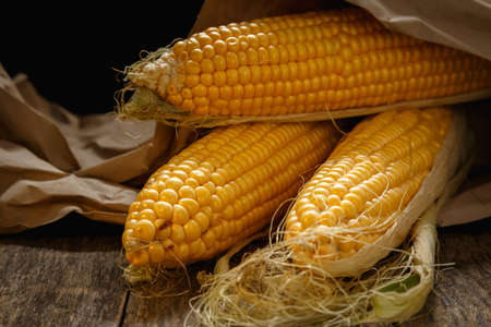 Fresh corn on the cob on a rustic wooden table, close up. Delicious and healthy food.の写真素材
