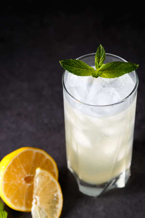Refreshing summer non-alcoholic lemonade with ice, fresh mint and lemon. Top view, place for text. Fruit background with copy space. Still life food.の写真素材