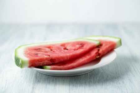 Sliced watermelon, honey watermelon on wooden table background. Very healthy, natural, vegetarian food.の写真素材