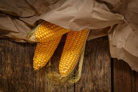 Fresh corn on the cob on a rustic wooden table, close up. Delicious and healthy food.の写真素材