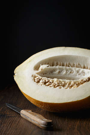 Whole melon, honey melon on wooden table background. Very healthy, natural, vegetarian food.の写真素材