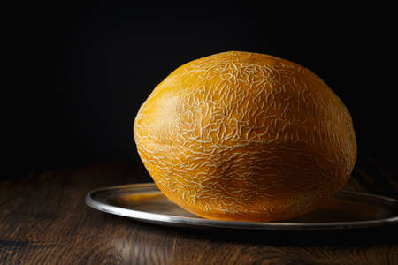 Whole melon, honey melon on wooden table background. Very healthy, natural, vegetarian food.の写真素材