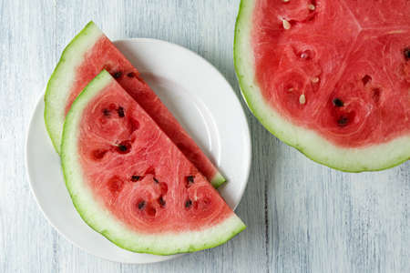 Whole and sliced watermelon, honey watermelon on wooden table background. Very healthy, natural,...