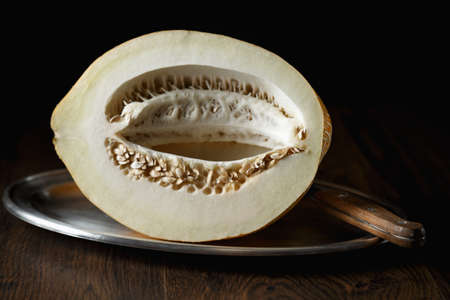 Whole melon, honey melon on wooden table background. Very healthy, natural, vegetarian food.の写真素材