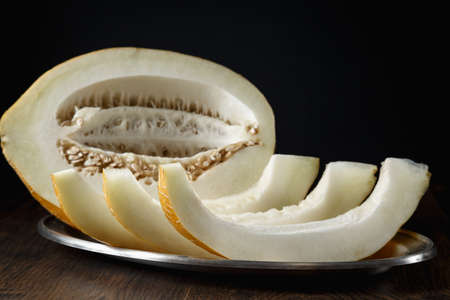 Whole and sliced melon, honey melon on wooden table background. Very healthy, natural, vegetarian food.の写真素材