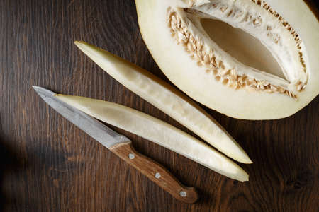 Whole and sliced melon, honey melon on wooden table background. Very healthy, natural, vegetarian food.の写真素材