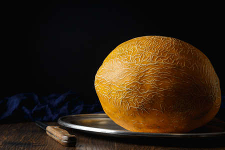 Whole melon, honey melon on wooden table background. Very healthy, natural, vegetarian food.の写真素材