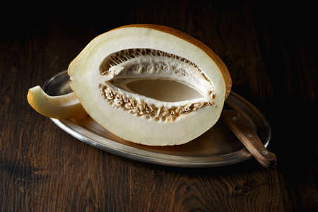 Whole and sliced melon, honey melon on wooden table background. Very healthy, natural, vegetarian food.の写真素材