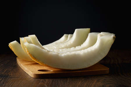 Sliced melon, honey melon on wooden table background. Very healthy, natural, vegetarian food.の写真素材