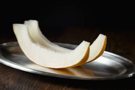 Sliced melon, honey melon on wooden table background. Very healthy, natural, vegetarian food.の写真素材