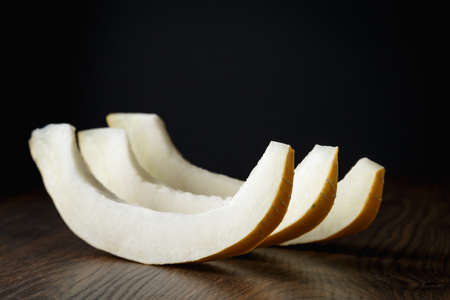 Sliced melon, honey melon on wooden table background. Very healthy, natural, vegetarian food.の写真素材