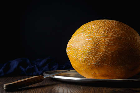 Whole melon, honey melon on wooden table background. Very healthy, natural, vegetarian food.の写真素材