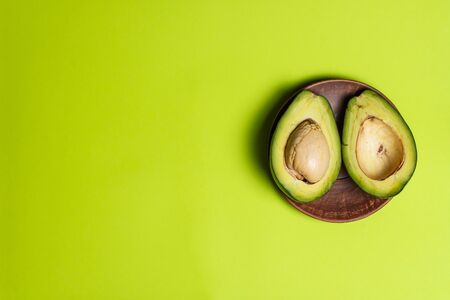 Sliced green colored avocado on a green backgroundの写真素材