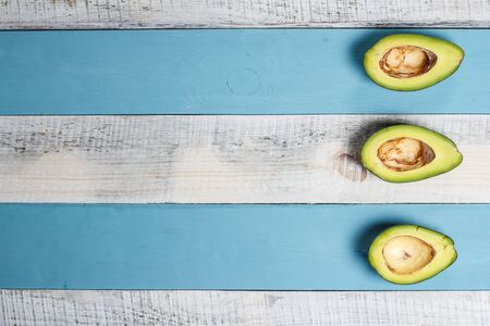 Sliced green avocado on a wooden blue surface