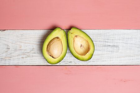 Sliced green avocado on a red beautiful surfaceの写真素材