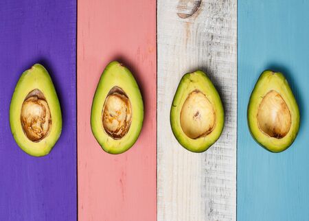 Green avocado on a colored wooden surface