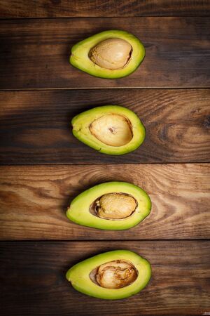 Sliced green avocado on a brown wooden table