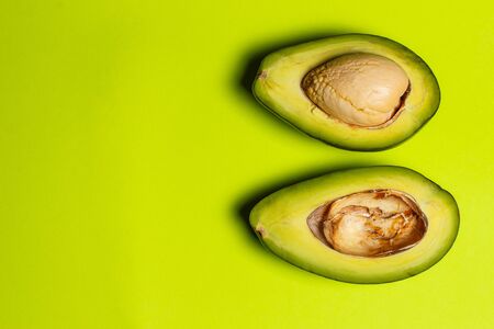 Halved avocado on a green background