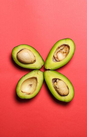 Sliced green avocado on a red beautiful surfaceの写真素材