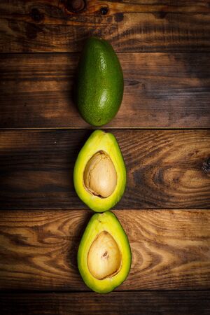 Sliced green avocado on a brown wooden tableの写真素材