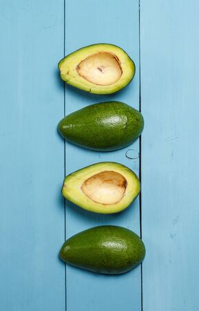 Sliced green avocado on a wooden blue surfaceの写真素材