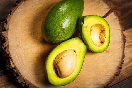 Sliced green avocado on a brown wooden tableの写真素材