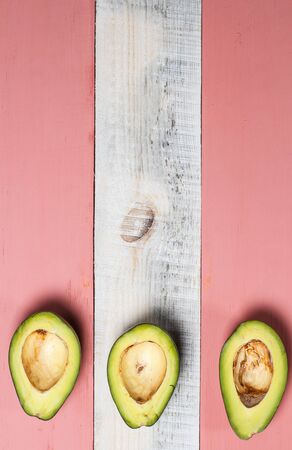 Sliced green avocado on a red beautiful surfaceの写真素材