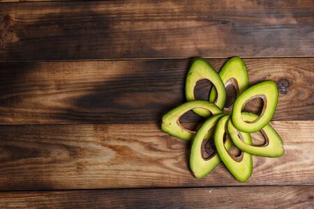 Sliced green avocado on a brown wooden tableの写真素材