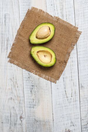 Sliced green avocado on a white surface in provence styleの写真素材
