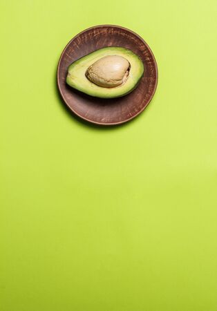 Sliced green colored avocado on a green backgroundの写真素材