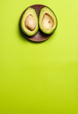Sliced green colored avocado on a green backgroundの写真素材