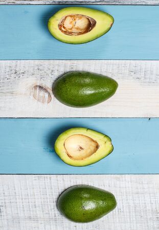 Sliced green avocado on a wooden blue surfaceの写真素材