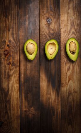 Sliced green avocado on a brown wooden tableの写真素材