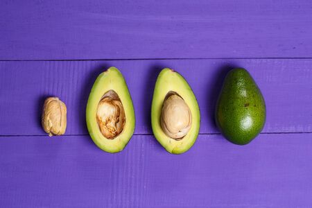 Sliced green avocado on a purple wooden backgroundの写真素材