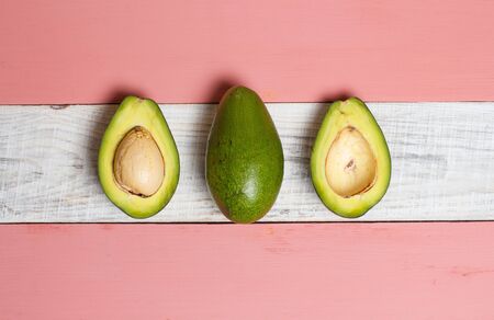 Sliced green avocado on a red beautiful surfaceの写真素材
