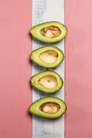 Sliced green avocado on a red beautiful surfaceの写真素材