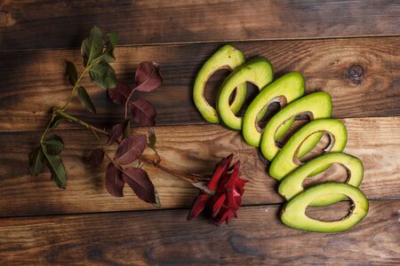 Sliced green avocado on a brown wooden table