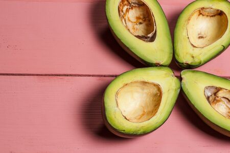 Sliced green avocado on a red beautiful surfaceの写真素材