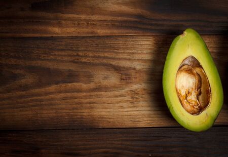 Sliced green avocado on a brown wooden tableの写真素材