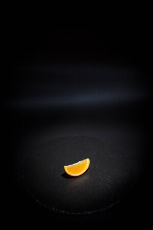 Sweet ripe orange on a black surface and black backgroundの写真素材