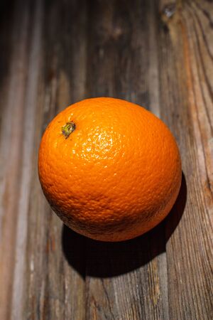 Ripe and tasty orange on a brown wooden surfaceの写真素材