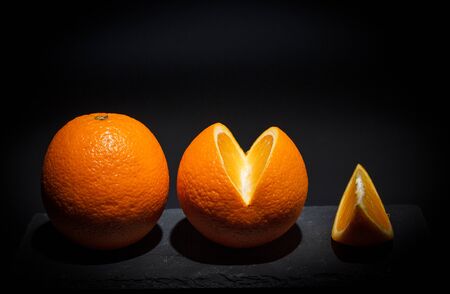 Sweet ripe orange on a black surface and black backgroundの写真素材