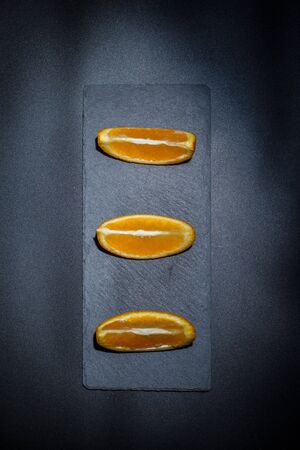 Sweet ripe orange on a black surface and black backgroundの写真素材