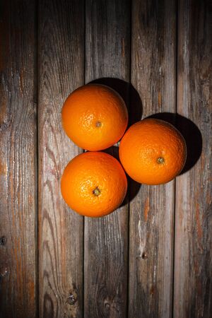 Ripe and tasty orange on a brown wooden surface